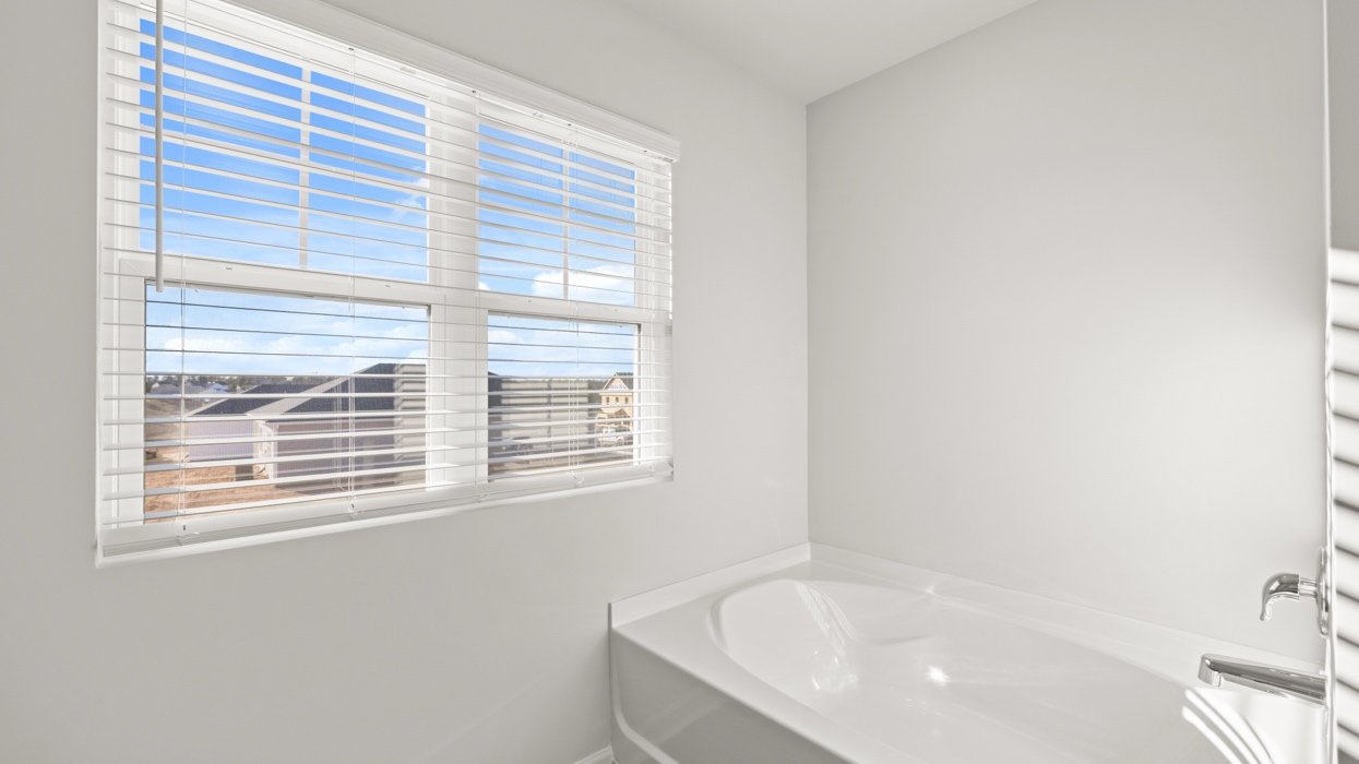 Primary bath with double vanity, garden tub, shower with glass door, and water closet.