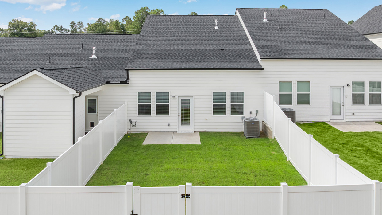 Rear of townhome with back patio and backyard.