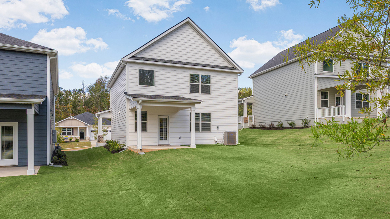 Rear of Two story home with covered front porch and one car garage