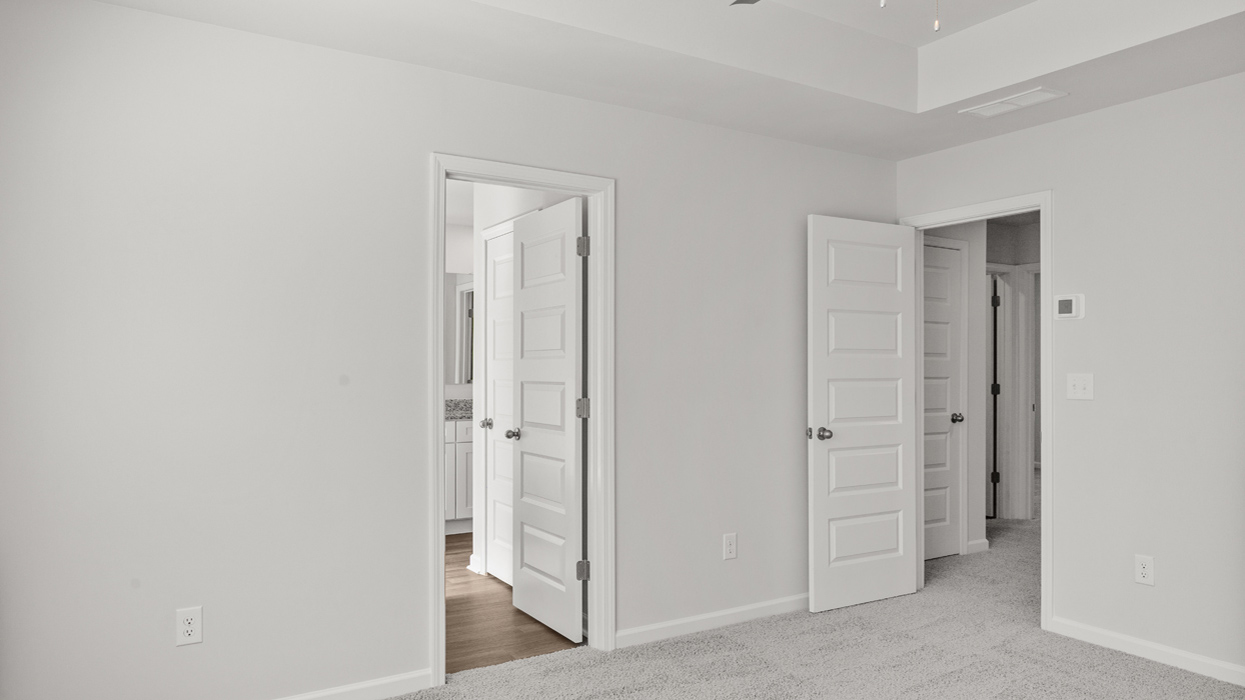 Primary bedroom on second floor with tray ceilings