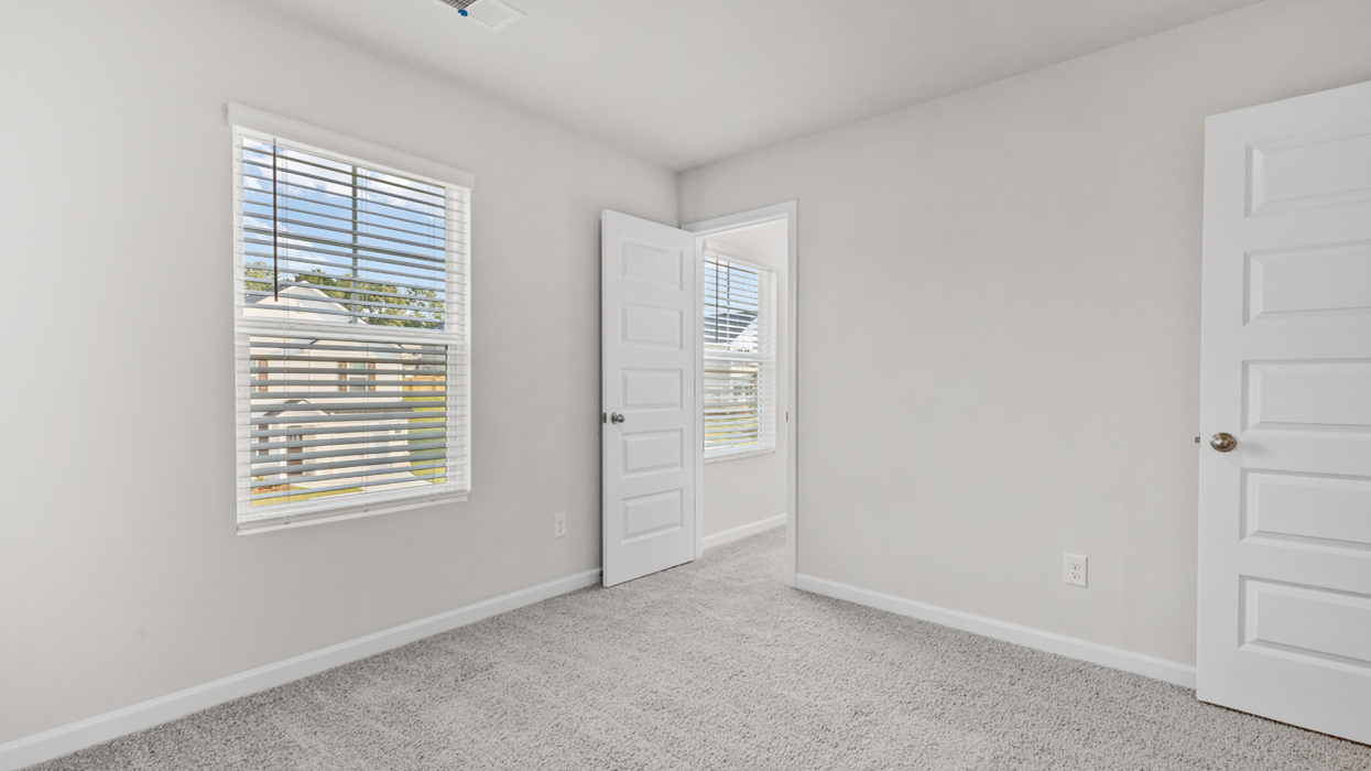 Guest bedroom with carpeting and expansive closet.