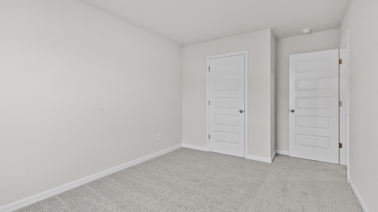 Guest bedroom upstairs with carpeting.