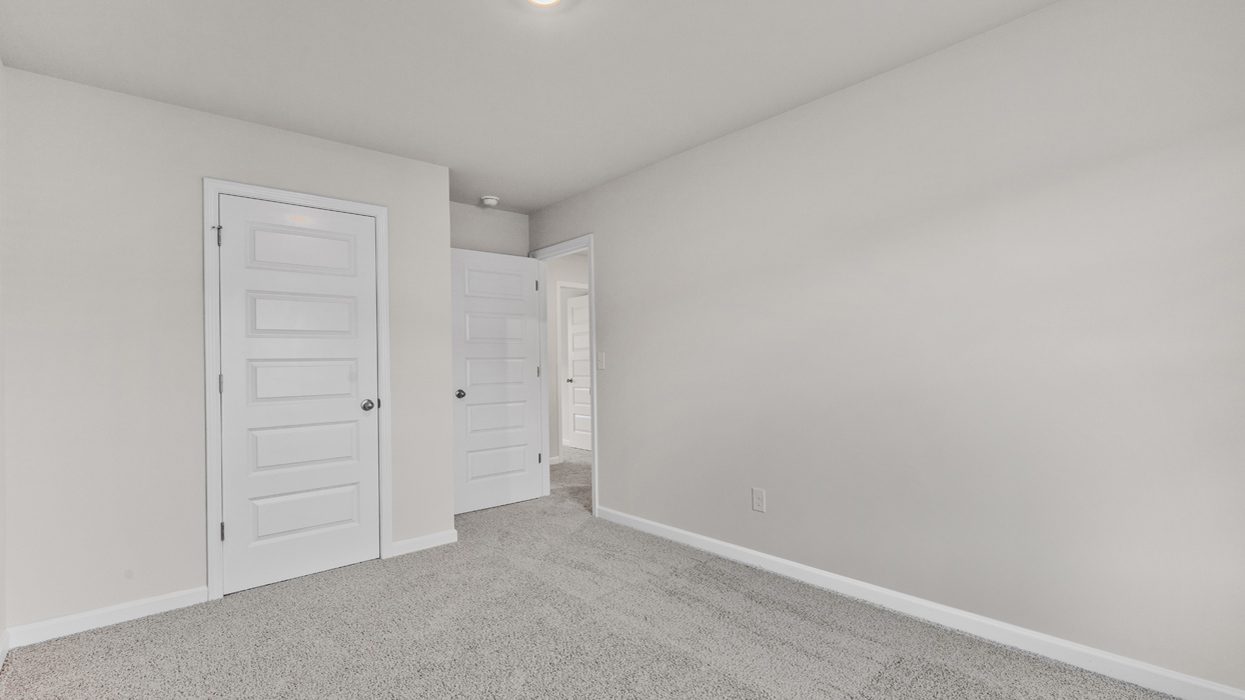 Guest bedroom upstairs with carpeting.