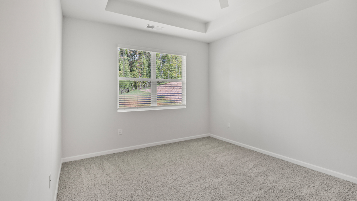 Primary bedroom with tray ceilings and en suite bath.