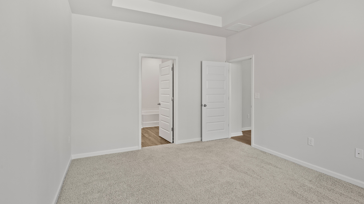 Primary bedroom with tray ceilings and en suite bath.