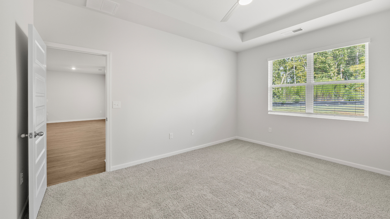 Primary bedroom with tray ceilings and en suite bath.