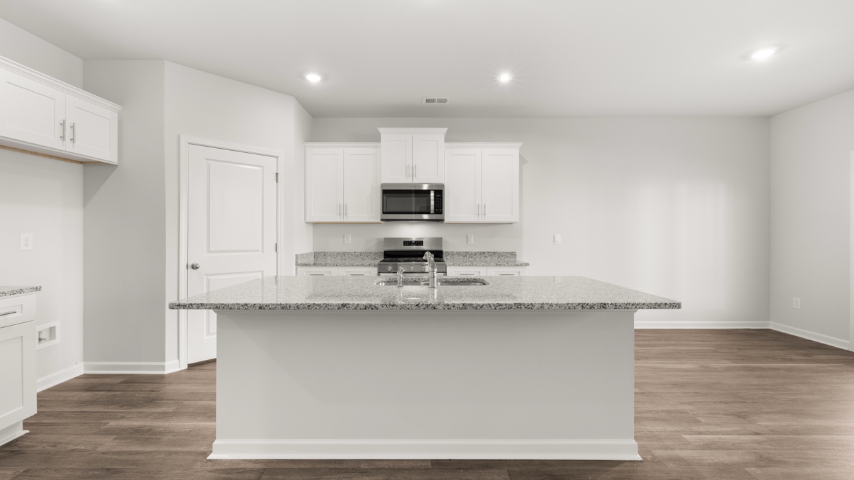 Modern kitchen with quartz countertops, stainless appliances, tile backsplash, and large center island with bar seating