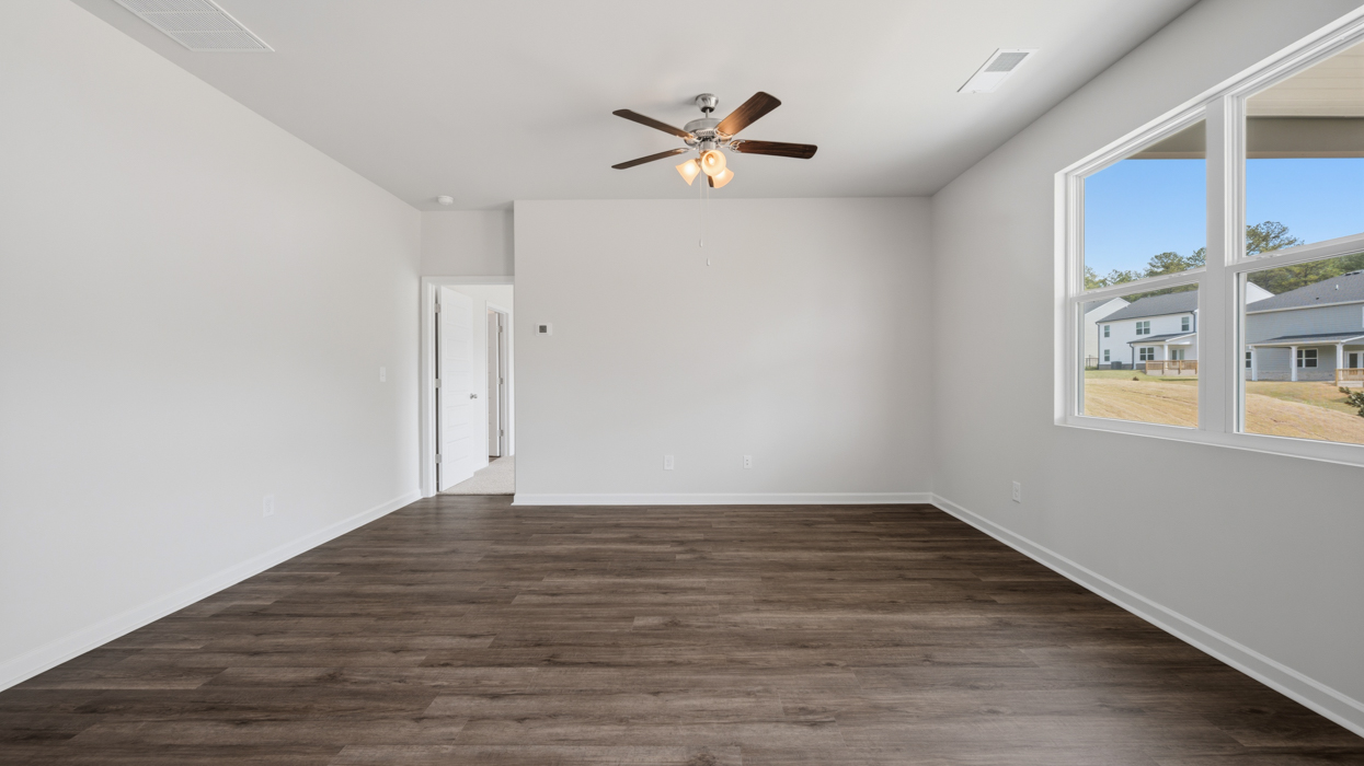 Open plan featuring kitchen with quartz countertops, tile backsplash, corner pantry, stainless appliances, and large center island overlooking dining and living room.