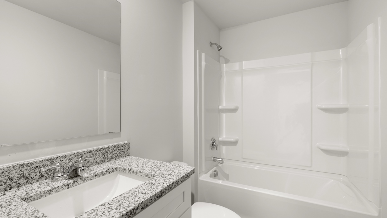 Guest bath upstairs with single vanity, commode, and combo tub/shower.