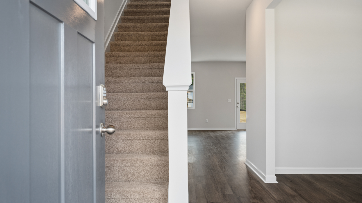Front door opening to main entry with stairwell on left and flex room on right.