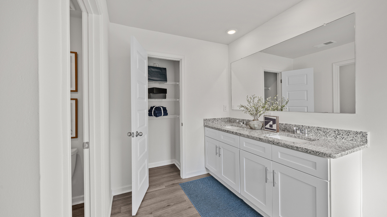 Primary bath with water closet with commode, garden tub, shower with glass door, and double vanity