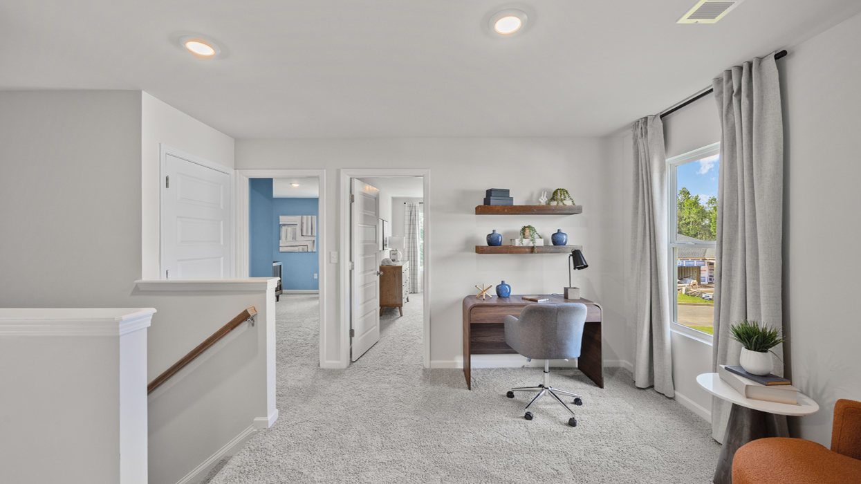 Loft upstairs at top of staircase landing with carpeting and storage closet.