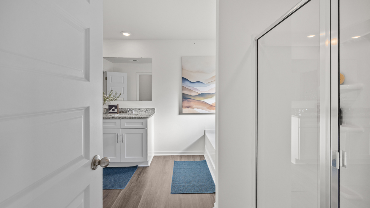 Primary bath with shower with glass door, soaking tub, double vanity, linen closet, and water closet with commode.