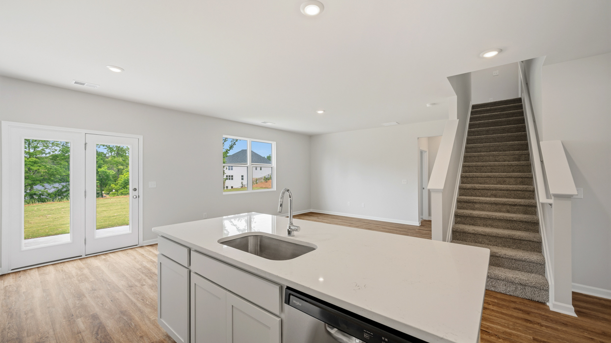 Modern kitchen with quartz countertops, tile backsplash, stainless appliances, and large center island with bar countertop