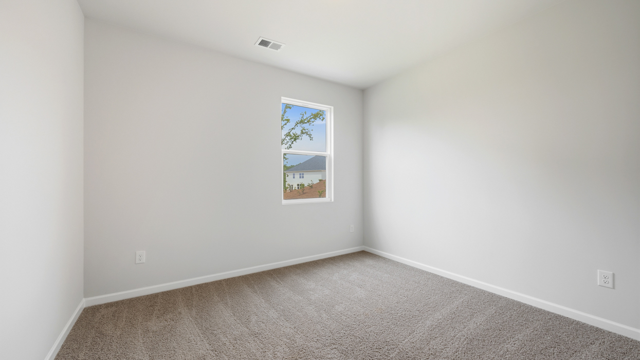 Guest bedroom downstairs with carpeting.