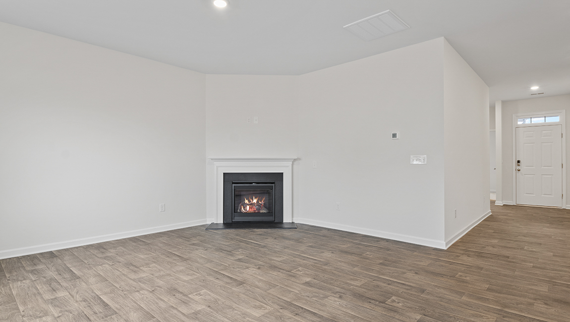 Open living room with wood floors, large window, and fireplaceOpen living room with wood floors, large window, and fireplace