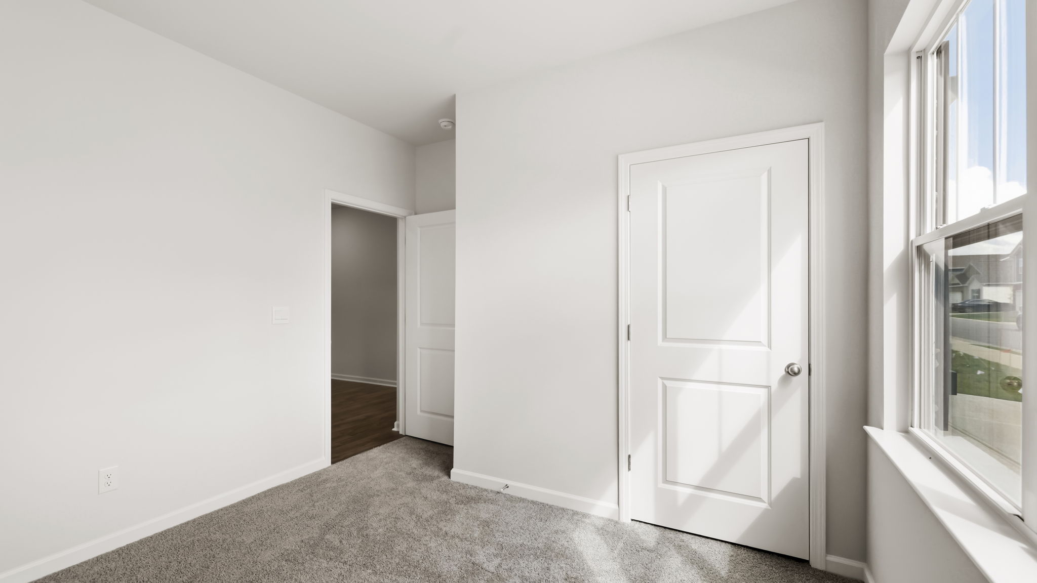 Carpeted bedroom with large window
