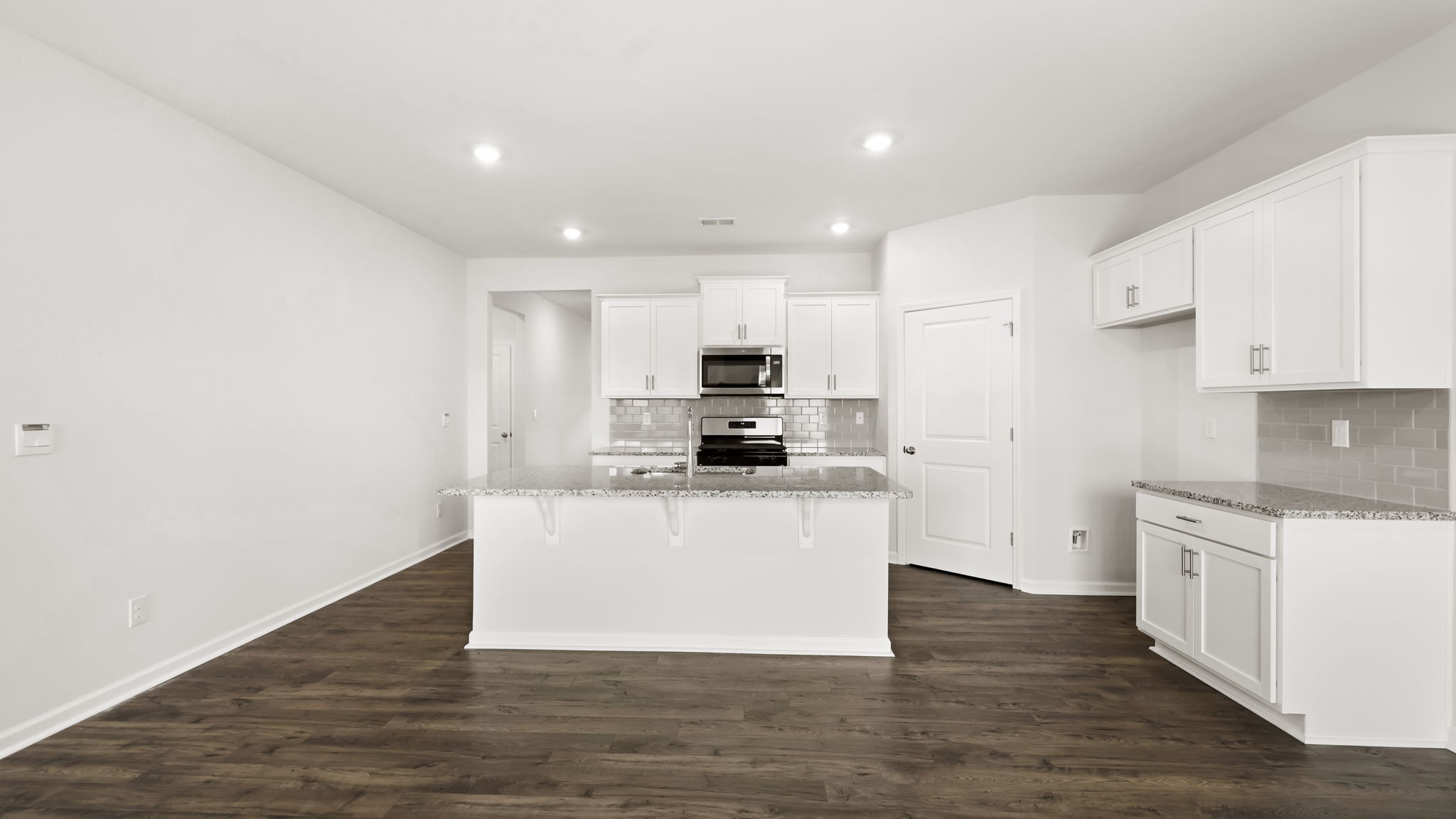 Open concept kitchen with stainless-steel appliances and large island