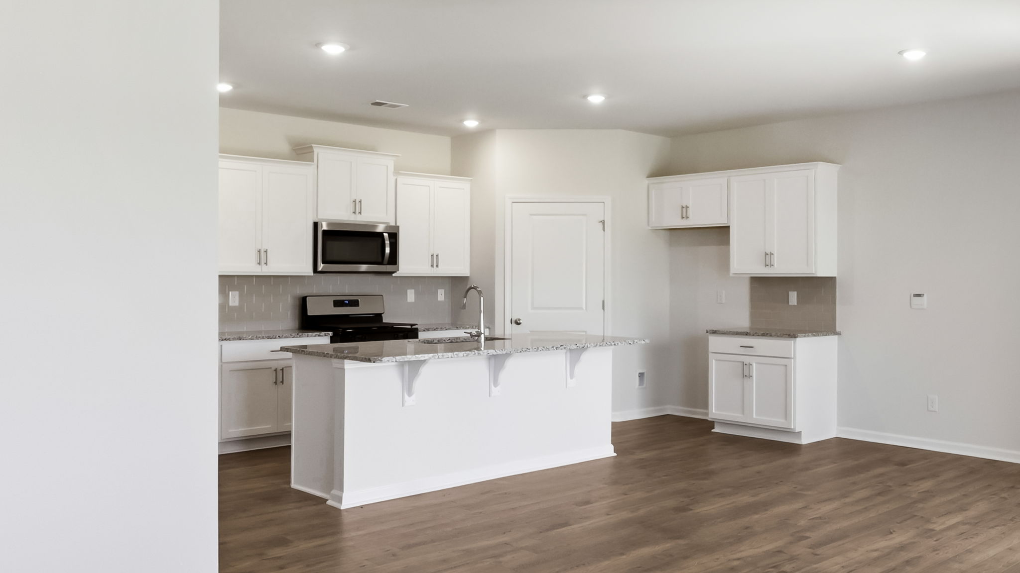 Open concept kitchen with stainless-steel appliances and large island