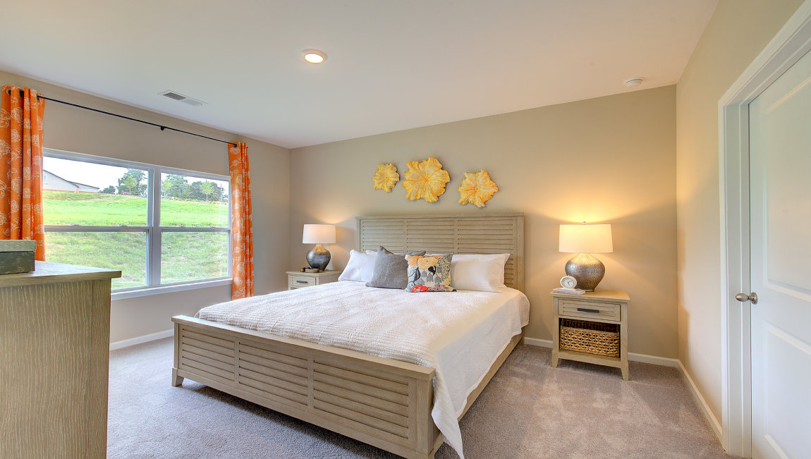 Carpeted primary bedroom with large windows