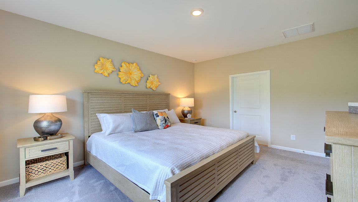 Carpeted primary bedroom with large windows