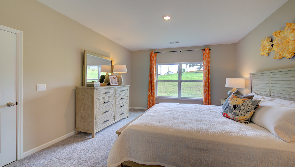 Carpeted primary bedroom with large windows