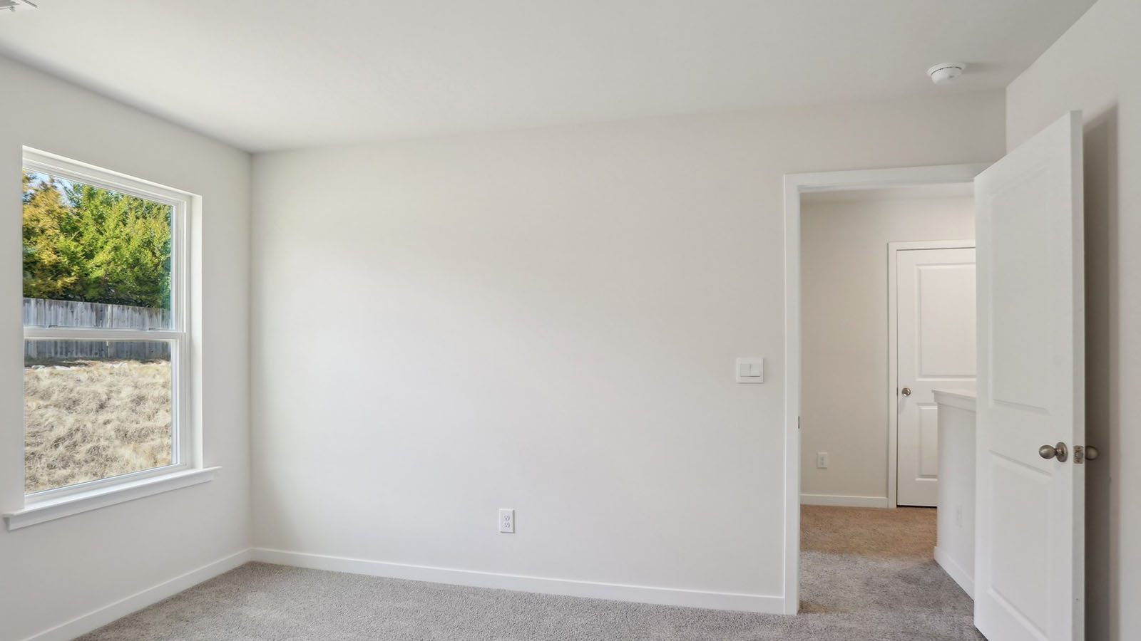 Carpeted bedroom with windows