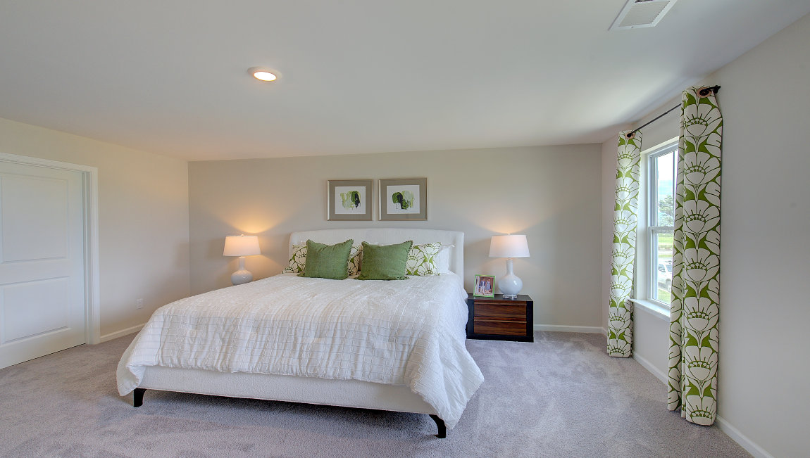 Carpeted primary bedroom with large windows