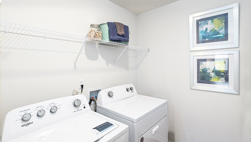 Laundry Room with racks above machines