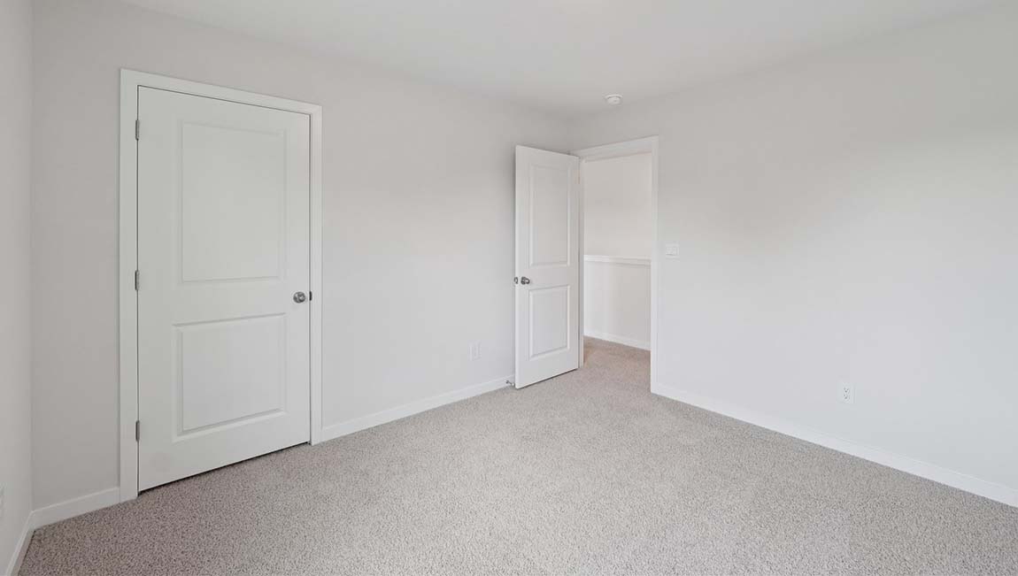 Carpeted bedroom with closet