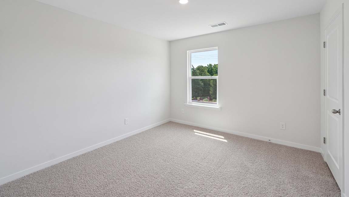 Carpeted bedroom with large window
