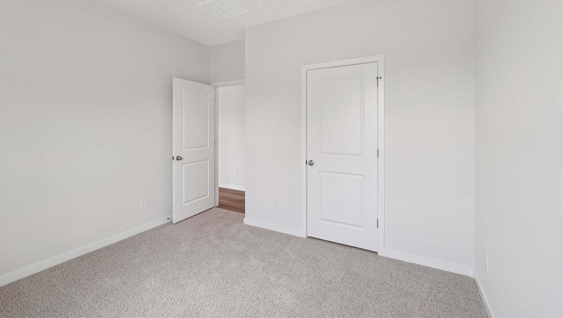 Carpeted bedroom with closet