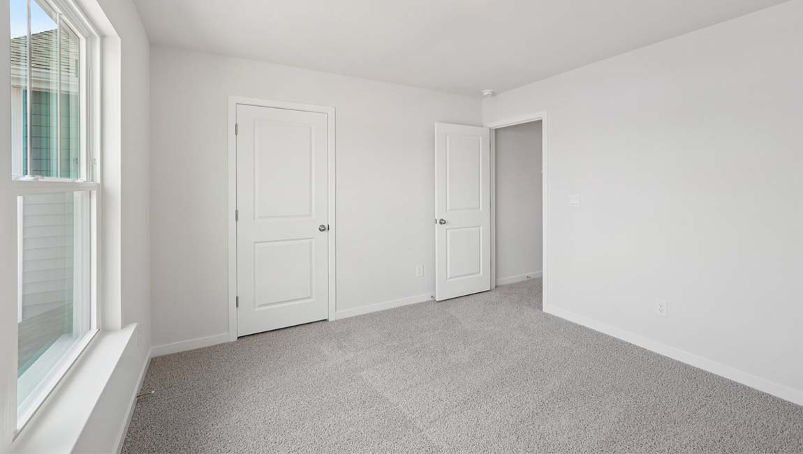 Carpeted bedroom with closet