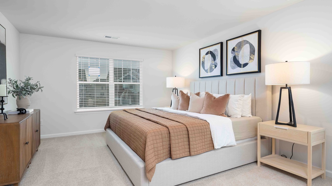 Carpeted primary bedroom with large windows