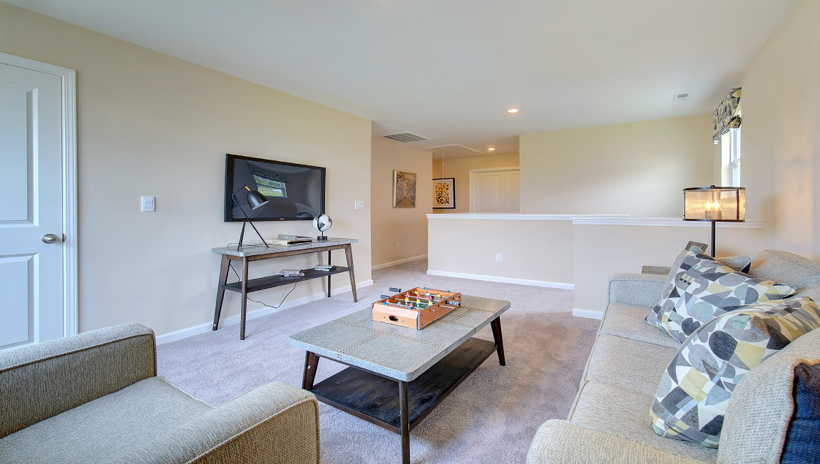 Carpeted loft space atop stairs with large window