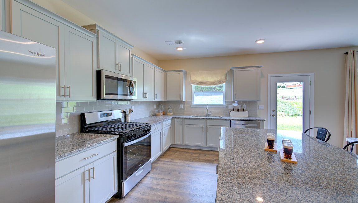 Kitchen and island with white counters and cabinets