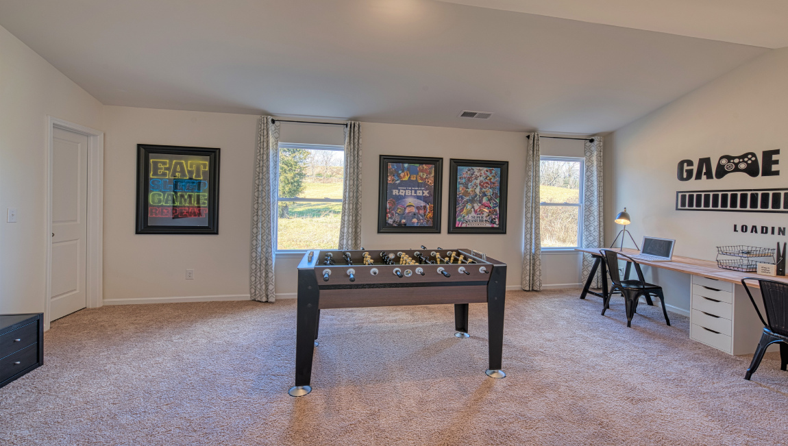 Carpeted bonus room with large windows