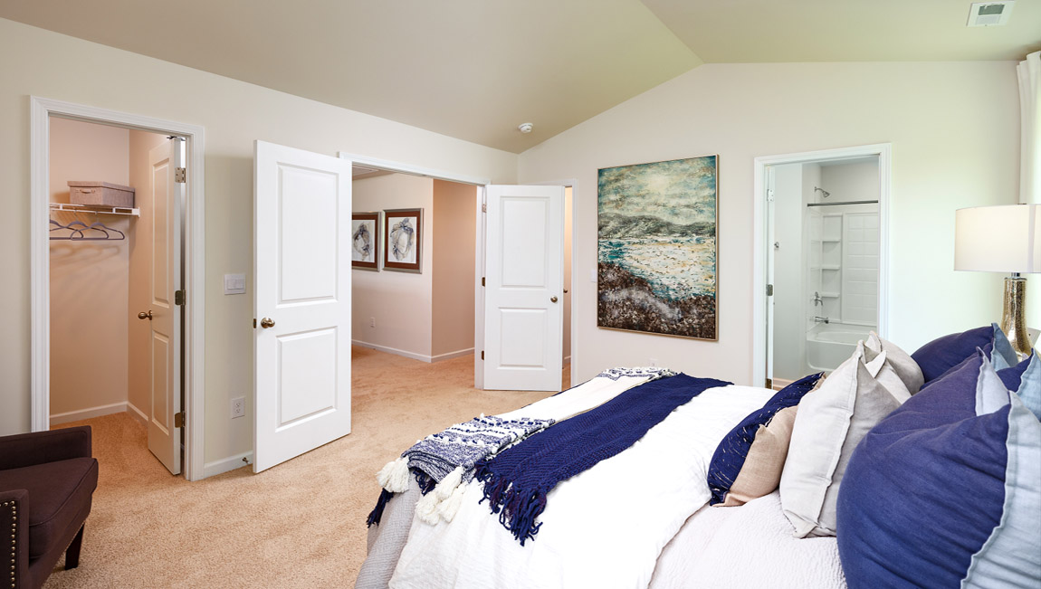 Carpeted second primary bedroom with large windows