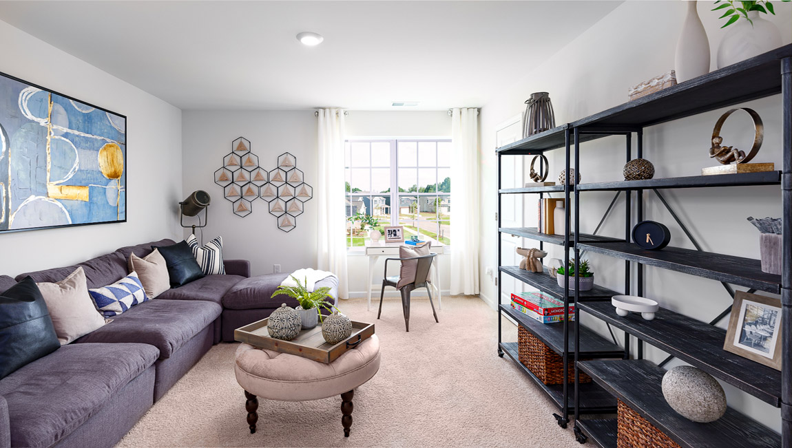 Carpeted loft area with windows