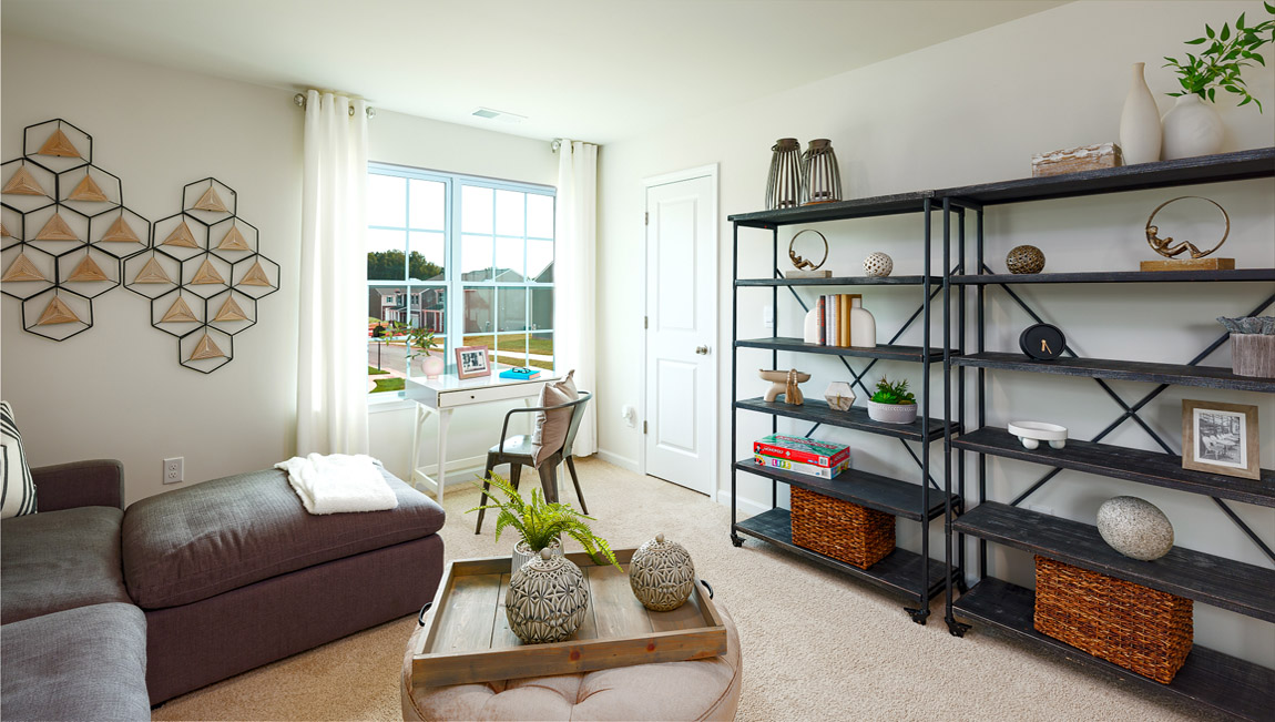 Carpeted loft area with windows