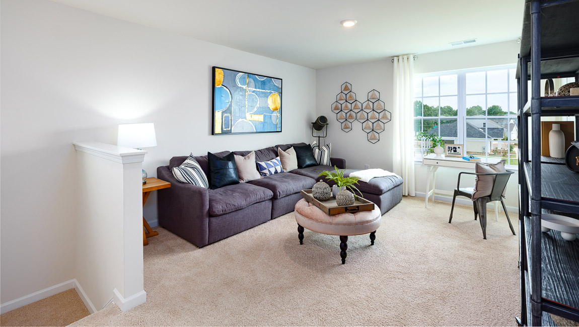Carpeted loft area with windows