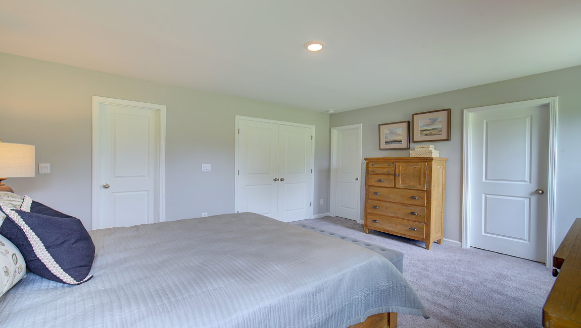 Carpeted primary bedroom with large windows