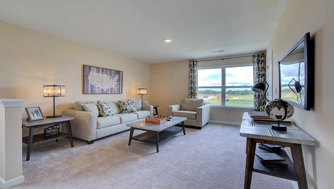 Carpeted loft area with large windows
