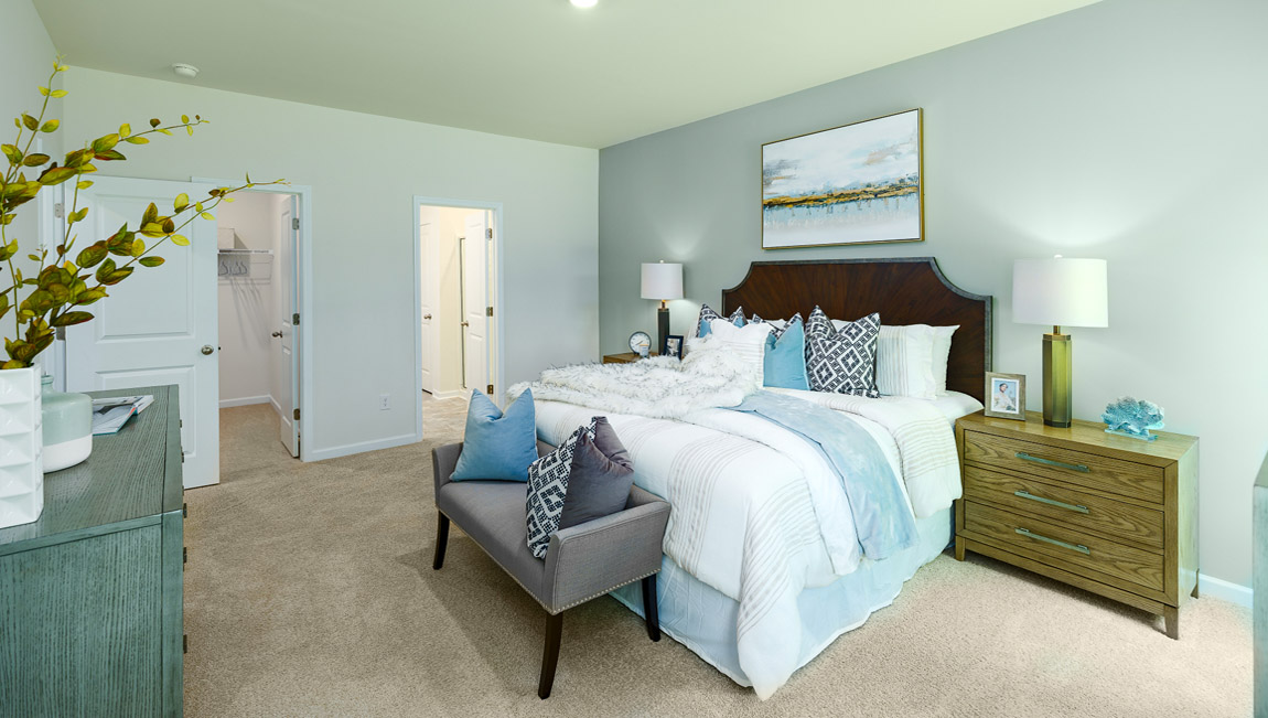 Carpeted primary bedroom with two small windows