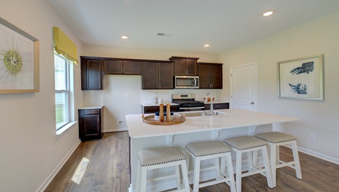Kitchen and island with brown cabinets, white countertops, and stainless steel appliances