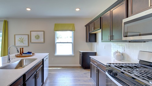 Kitchen and island with brown cabinets, white countertops, and stainless steel appliances