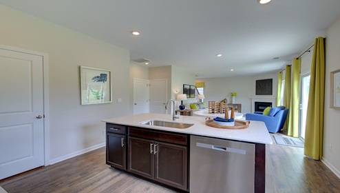 Kitchen and island with brown cabinets, white countertops, and stainless steel appliances