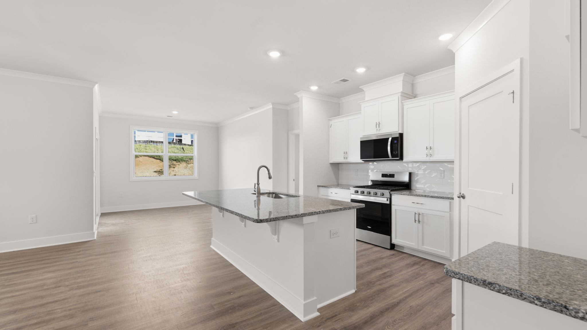 Modern, open concept kitchen with island and stainless-steel appliances