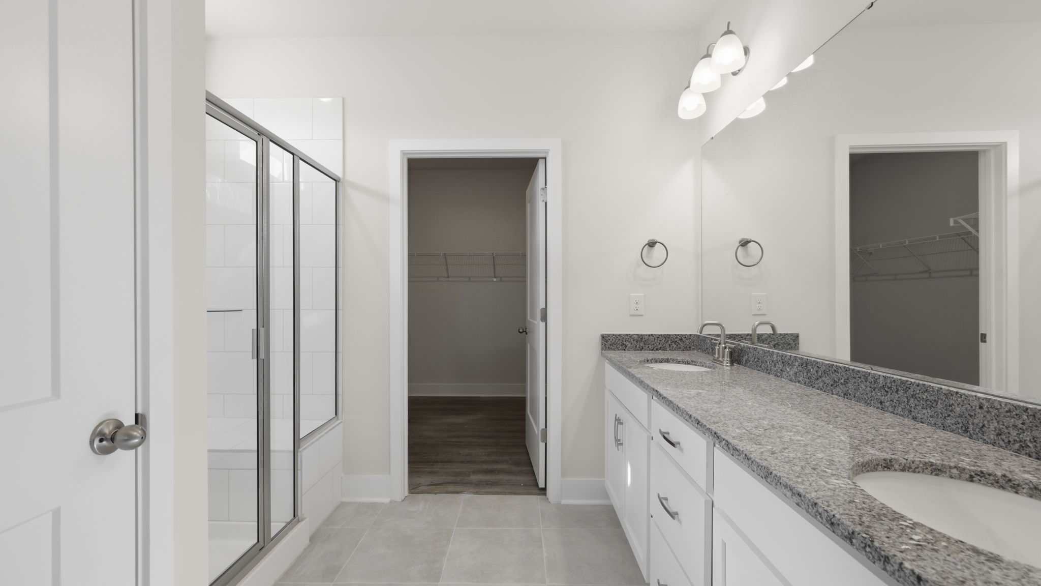 Primary ensuite bathroom with dual vanity, large walk in shower and walk in closer