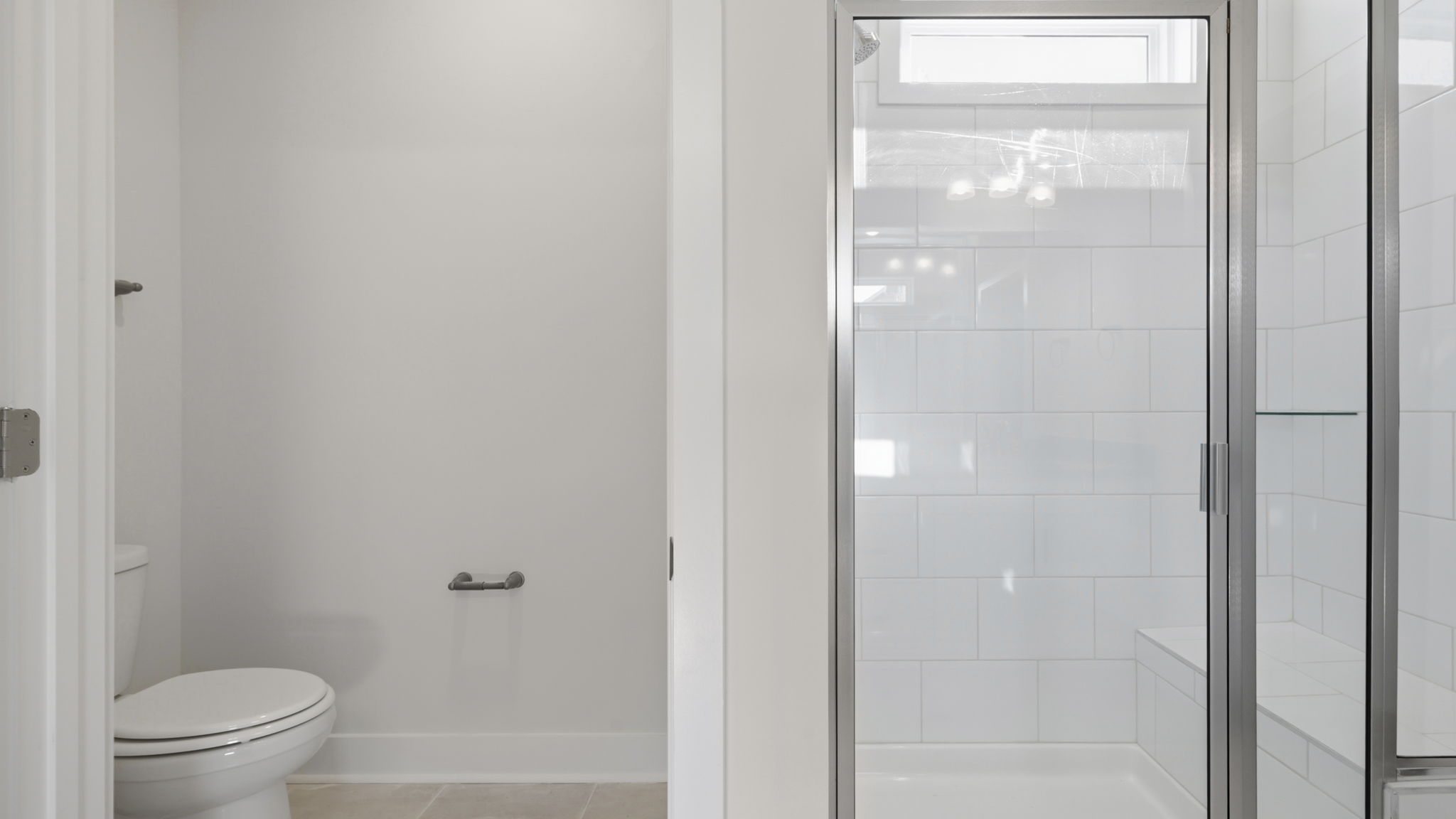 Toilet closet view with large walk in shower, with glass door